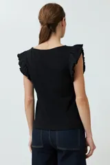 Top de punto canalé color fucsia, con cuello redondo y mangas cortas con volados decorativos en los hombros.