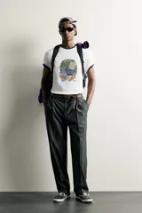 Camiseta regular fit blanca de manga corta y cuello redondo, con un estampado gráfico en el frente que ilustra ropa y accesorios.
