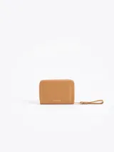 Billetera compacta de cuero vacuno color bordó, con cierre perimetral, correa de muñeca y aplique metálico dorado en forma de mariquita en el frente.