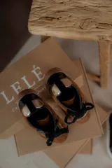 Championes marrones de cuero con cordones negros, puntera de charol y detalles dorados.