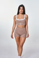 Conjunto deportivo compuesto por un top y un short de color habano con detalles de costuras blancas. El top es de escote redondo con breteles anchos y el short es de tiro alto con diseño ajustado.