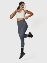 Top deportivo de sujeción media, color blanco, confeccionado en tejido suave y elástico con Aloe Vera. Presenta un diseño de espalda cruzada y dos tiras con aberturas en los hombros.