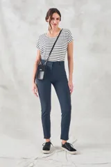 Pantalón de vestir azul marino, de corte skinny y tiro medio, con bolsillos laterales y cierre invisible en el lateral.