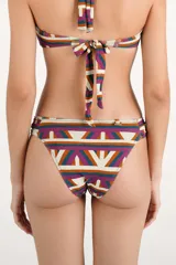 Bombacha de bikini con diseño geométrico multicolor y argollas decorativas en los laterales.
