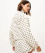 Campera rompeviento deportiva Get Over de microfibra, con estampado de lunares, cuello alto, cierre frontal oculto, bolsillos delanteros con ribete oscuro y puños elásticos.