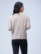 Buzo de lana melange color tostado, con cuello redondo y mangas largas.