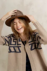 Saco tejido de punto con diseño de guarda inca en la parte superior. Presenta bolsillos frontales con detalles de tiras de cuero y flecos. De corte recto y largo medio, con terminaciones en tejido acanalado.