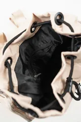 Mochila de nylon color lila con cierre de hebilla frontal, bolsillo exterior con cierre y bolsillos laterales con cierre.