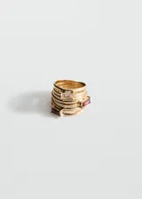 Set de anillos apilables en tono dorado, compuesto por varias bandas finas. Algunos anillos presentan apliques de cristales rectangulares en colores transparente y rojo.