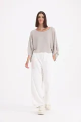 Pantalon deportivo de corte holgado y tiro alto, color blanco, con detalle de strass aplicado en toda la prenda. Posee cintura elastizada con cordón de ajuste y bolsillos laterales.