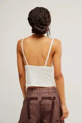 Musculosa de punto acanalado blanca, de calce ajustado y corto, con escote en V profundo, tiras finas y detalle de encaje en contraste bajo el escote.