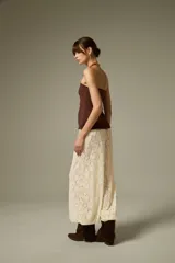 Pantalón tipo babucha de encaje color crudo, con corte holgado y cintura elástica.