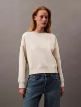 Buzo de cuello redondo color beige, confeccionado en suave tejido fleece. Presenta un logo de archivo de Calvin Klein bordado en el frente.