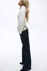 Jean de tiro alto con corte wide leg, confeccionado en denim rígido de color azul oscuro. Presenta diseño de cinco bolsillos, cierre con botón y ruedo deshilachado.