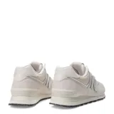Championes urbanos New Balance modelo 574, color marfil, confeccionados en gamuza y malla con detalles texturizados en la puntera. Presentan el logo N característico en los laterales y suela con diseño moteado.