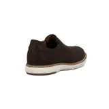 Zapato mocasín de cuero color marrón oscuro, sin cordones, con elástico lateral y suela blanca.