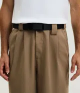 Cinturón ajustable de poliéster con cinta de trama gruesa y hebilla plástica negra. Cuenta con regulador para un ajuste preciso y resistente.