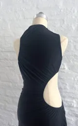 Vestido negro de fiesta, largo midi, con un solo hombro y abertura en la cintura.