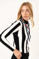 Polera de tejido de punto con diseño de rayas verticales anchas en blanco y negro, cuello alto y manga larga.