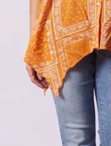 Camisa celeste con estampado de cachemir en blanco, cuello a la base, escote en V y abertura central con botones. Terminación de ruedo asimétrico. Manga 3/4 de largo regulable con presilla y botón.