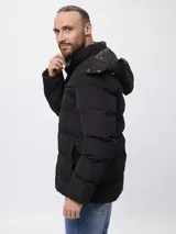 Campera puffer de nylon con capucha desmontable, cierre frontal y bolsillos laterales con cierre.