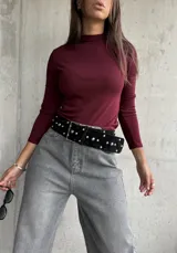 Polera de cuello alto y manga larga, confeccionada en tejido de punto acanalado de color bordó.