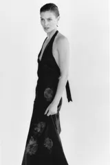 Vestido largo de Zara Woman Collection confeccionado en tejido satinado negro con estampado floral a contraste. Presenta cuello halter ajustable con lazada en la espalda y corte fluido.