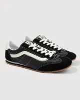 Championes Vans modelo Super Lowpro, de perfil bajo inspiradas en el diseño Serio. Presentan una combinación de ante y material sintético en color negro con detalles en blanco, incluyendo la icónica Sidestripe lateral, cordones blancos y suela de caucho con diseño Waffle.