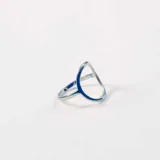 Anillo plateado de acero quirúrgico con diseño abierto y minimalista.