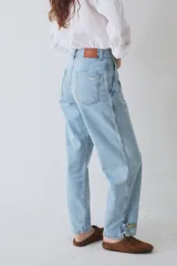 Pantalón tipo bombacha de campo confeccionado en denim azul. Presenta pinzas frontales, cierre de botones en los tobillos para ajustar la silueta y costuras reforzadas.