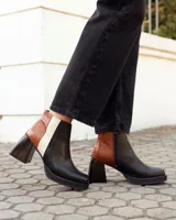 Botinetas de cuero con diseño tricolor en negro, marrón con textura croco y blanco. Presentan taco cuadrado, plataforma y cierre lateral.