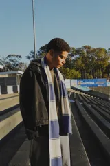 Bufanda larga de tejido de punto con rayas horizontales anchas en color blanco y azul.