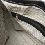 Bolso hobo negro de cuero sintético con correa ancha con el logo de la marca en blanco.