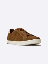 Zapatillas acordonadas de cuero nobuck color marrón con diseño calado y suela blanca de goma.