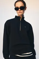 Sudadera de algodón con cuello alto y cierre frontal de cremallera metálica dorada. Presenta manga larga con puños elásticos, bajo elástico y detalle de logo metálico en el pecho.