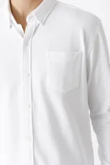 Camisa de hombre color azul marino, de piqué con cuello abotonado y manga larga.