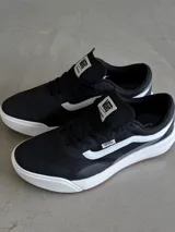 Championes Vans Ultrarange 2.0 RW, color negro con franja lateral blanca, entresuela blanca y suela de goma marrón.