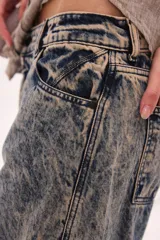 Jean de algodón con fit barrel y tiro bajo, en color azul con efecto deslavado y manchas en tono beige. Cuenta con bolsillos delanteros y traseros.
