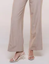 Pantalón sastrero de talle alto y corte wide leg, color beige, con pretina ancha, pasacintos, bolsillos laterales funcionales y bolsillos traseros ojalados.