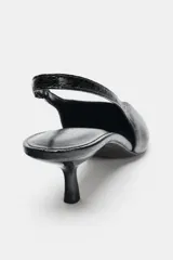 Zapato destalonado con tacón fino, acabado en punta y textura con efecto relieve. Cuenta con tira trasera elástica para mayor ajuste.