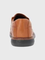 Zapato tipo mocasín de cuero color tostado, con diseño de costuras reforzadas y suela de goma EVA en color negro.