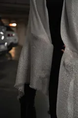 Pashmina de tejido ligero con acabado metalizado en tono oscuro, con bordes desflecados.