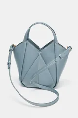 Bolso mini shopper de cuero sintético en color marrón, con diseño estructurado y costuras decorativas contrastantes. Cuenta con doble asa de mano y cierre magnético.