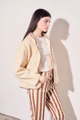 Campera beige de corderito vegano con cuello mao y cierre frontal con botones a presión.