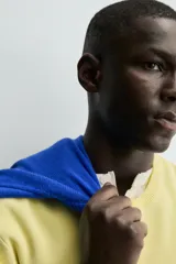 Camiseta de manga corta color amarillo pálido, con cuello redondo acanalado y corte relajado.