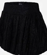 Minifalda negra de jacquard con tiro alto, cintura estructurada y corte baloné voluminoso.