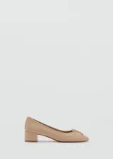 Zapato de salón color beige con tacón bloque bajo y adorno de lazo en la puntera.