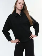 Buzo de cuello polo con escote abotonado, manga larga raglán y puños acanalados. Confeccionado en tejido suave y confortable.