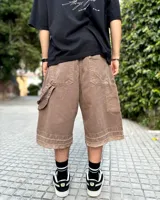 Bermuda de corte baggy color marrón con efecto gastado (lavado vintage), doble carpintero y detalle artesanal visible en el bajo. Incluye un cordón extra confeccionado en la misma tela.