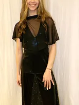 Capita corta de tul negro transparente con mangas cortas tipo capa y escote alto.